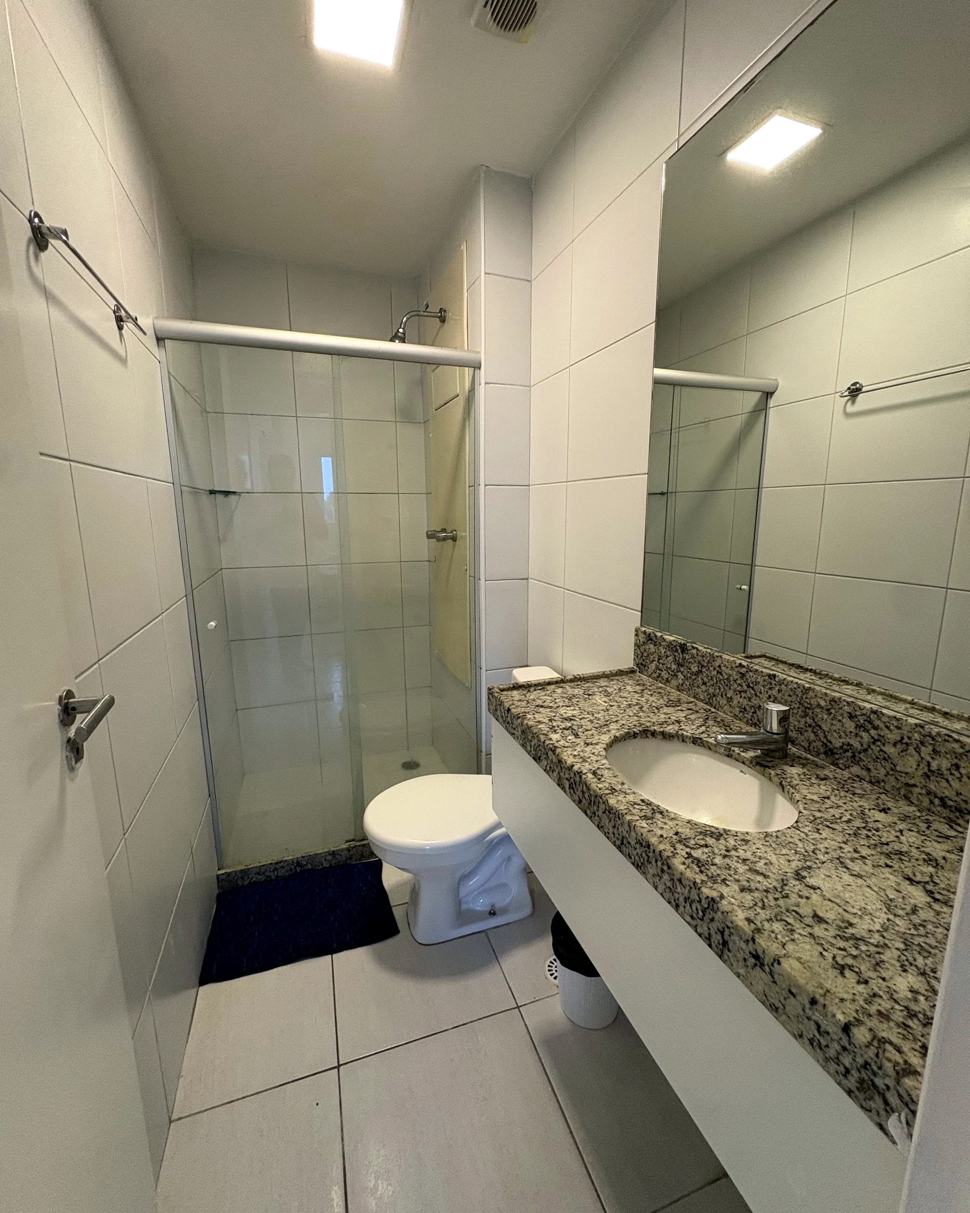 Banheiro com box de vidro e bancada de granito
