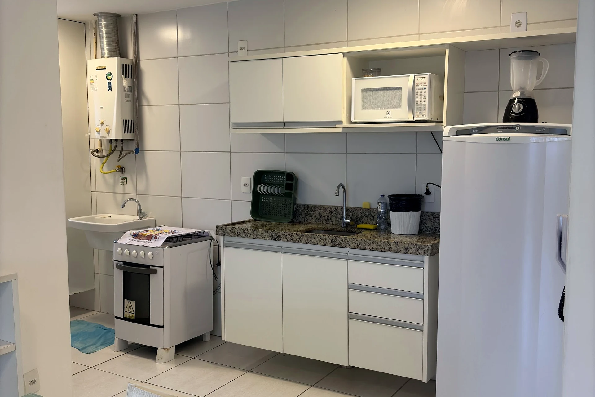 Cozinha equipada com fogão, geladeira e micro-ondas
