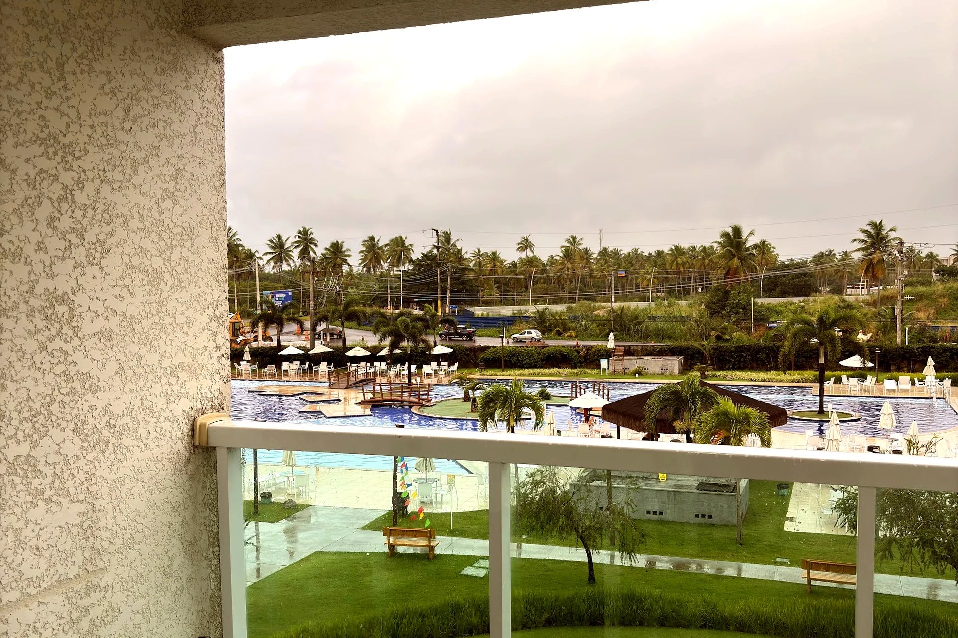 Varanda do apartamento com vista para o complexo de piscinas do condomínio
