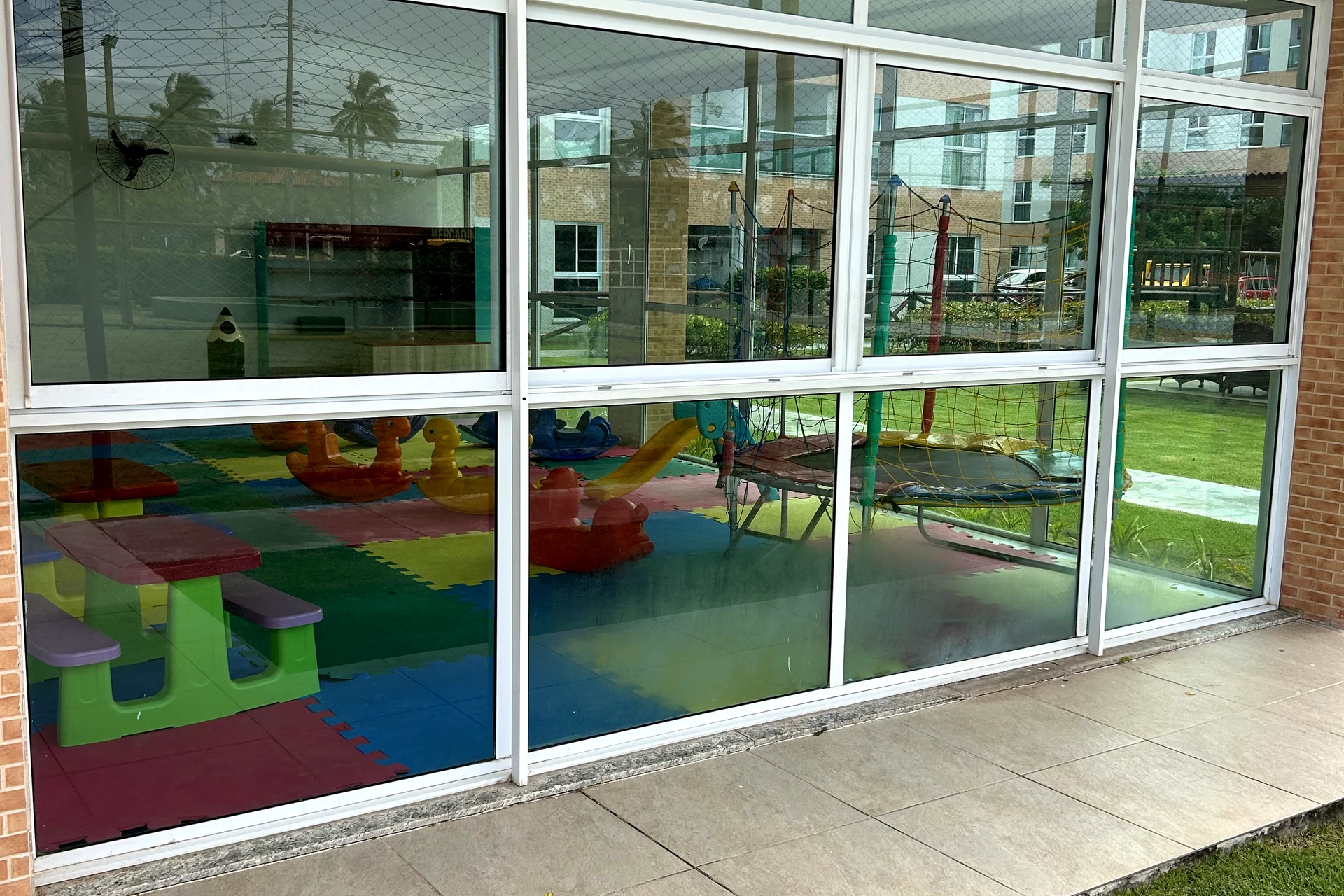 Espaço kids envidraçado com brinquedos coloridos