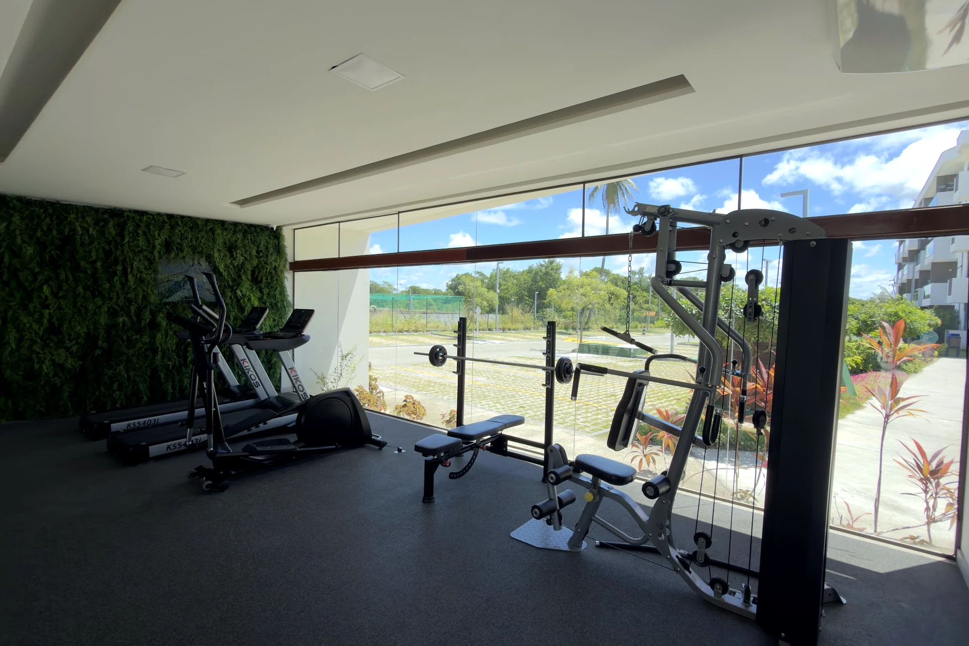 Academia envidraçada com aparelhos de musculação e vista para fora