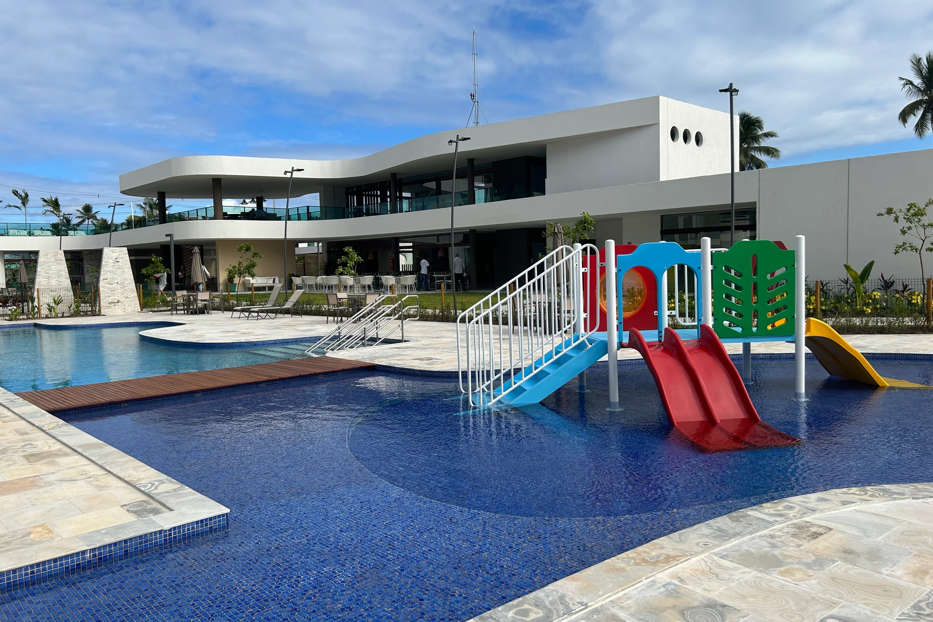 Piscina infantil com escorregadores coloridos diante da área de convivência do Makia