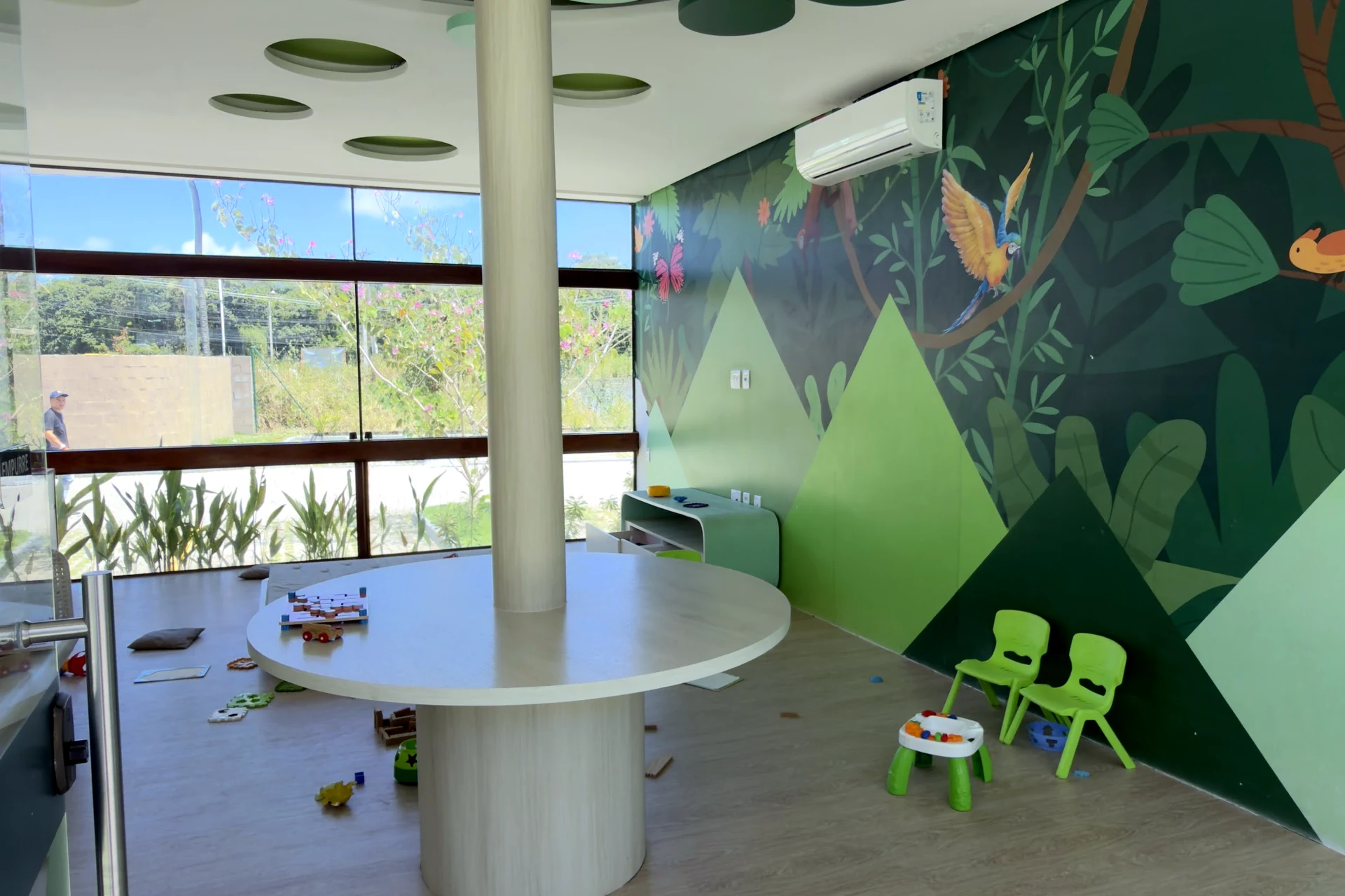 Brinquedoteca com painéis verdes e mobiliário infantil